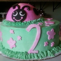 Ladybug Cake Lemon Cake covered in buttercream frosting. 10" bottom layer with big ball pan half as ladybug. Embellishments are mmf.