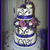 Purple And Black Wedding Cake I made this cake for a good friend of mine. It's frosted in buttercream with a fondant ribbon and fresh flowers.