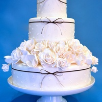 White Wedding Cake 3 tier round wedding cake with a 4th tier of sugar flowers, roses and tulips.