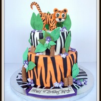 Tiger Cake Tiger is made from gumpaste. Design was originally made up by the birthday girl. She wanted a tiger, purple flowers and an orange cake. I...