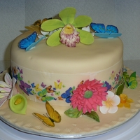 Butterfly And Flower Cake Chocolate cake with white chocolate mousse filling, covered in buttercream and fondant. Gumpaste butterflies and flowers/leaves.