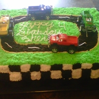 Race Track Cake sheet cake all buttercream track is made out of oreos i bought some trucks and placed them on the car..