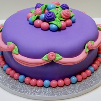 Pink And Purple Princess Cake 8 inch banana cake with chocolate buttercream covered in marshmallow fondant. All decorations also done in marshmallow fondant. For a 2-...