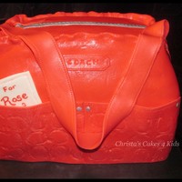 Red Coach Bag 4 layers of cake made covered in MMF. Added some tylose for the pockets and strap. Petal dust for the silver zipper, studs, and strap rings...