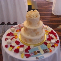 Gold And Ivory 3tier winter wedding cake. 2 tiers were dummies. The cake was covered in ivory fondant and then decorated with swirls and hand painted gold...