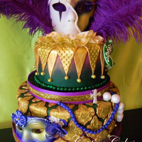 Mardi Gras Cake Everything made, masks, and all decorations, other then the feathers and crystal cross pins are made of fondant and hand painted.