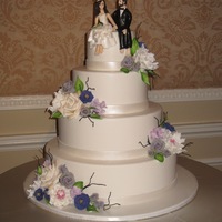 Playful Yet Romantic Summer Wedding Handmade barefoot figures made to look like bride and groom, with large bunches of handmade gumpaste flowers to mock the centerpiece floral...