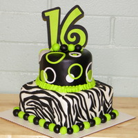 Green Sixteen! This is a double layer 8 inch square, and a double layer 6 inch round. The cakes are covered in MMF, and the decorations are wilton fondant...