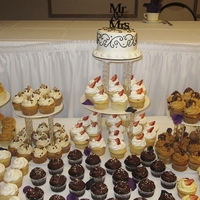 Black, White And Purple Wedding This wedding had 8 different Flavors of cupcakes. The cake is made with buttercream and I piped on the black scroll.