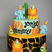 Safari Cake For Twins two tier safari cake for twin boys. There are handmade twin fondant animals featured.