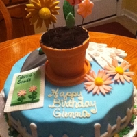 Flower Pot Birthday Cake Vanilla cake w/raspberry filling decorated with a flower pot and gardening tools