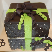 Georgia White choc mudcake, covered in fondant. Quilted effect on sides. Gumpaste/fondant bow and curly ribbons.