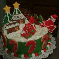 Christmas / Santa Cake A mixture of gumpaste, buttercream, royal icing and sugar cookie elements surrounding a buttercream and fondant covered cake.