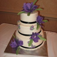 Deep Purple And Lavender Blossoms Compliment This Cake The Black Ribbon Set Off The Flowers Also The Bottom Layer Is Chocolate Filled Wi Deep purple and lavender blossoms compliment this cake. The black ribbon set off the flowers also. The bottom layer is chocolate filled...
