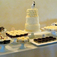 Vintage/shabby Chic Wedding Cake/cupcake Display 3 tier round wedding cake decorated in buttercream in a shabby chic/vintage style. Multiple flavors of cupcakes displayed on vintage style...