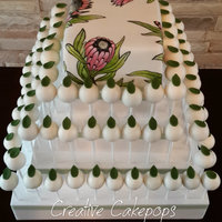 Hand Painted Protea Wedding Cake And Cake Pops Art Nouveau themed wedding cake and cake pops with handpainted Protea flowers and cake pops with leaf detail.
