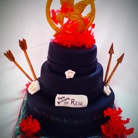 The Hunger Games This cake is based off of the book "The Hunger Games". The flames are sugar, pin is fondant and the roses are gumpaste.