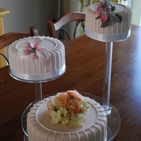 Pink Vintage Style Wedding Cake 3tier round pink fondant iced cake with royal iced piping , decorated with sugar flowers , the bottom tier is decorated with silk flowers