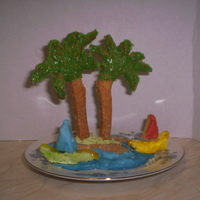 Gingerbread Island Shaped Biscuit With Gingerbread Palm Trees Inserted Added Blue Icing Around The Isle And Added Two Little Boats Gingerbread island shaped biscuit with gingerbread palm trees inserted, added blue icing around the isle and added two little boats.