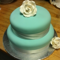Blue And White White ribbon and rose on a Tiffany blue cake.