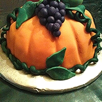 "harvest Pumpkin" Thanksgiving Cake PUMPKIN IS CROWNED WITH HAND CRAFTED FONDANT GRAPES, APPLE AND PEPPER...RED VELVET CAKE COVERED IN FONDANT.