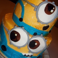 Minions!!! 2 tiered yellow cake, filled and frosted with buttercream, air brushed yellow and detailed with fondant