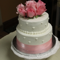 60Th Anniversary Cake White cake with raspberry filling. Covered in buttercream and topped with fresh pink roses