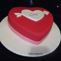 Heart Shaped Cake Covered In Red Fondant Heart Arrow Cut Using Cookie Cutter Heart shaped cake covered in red fondant. Heart arrow cut using cookie cutter.