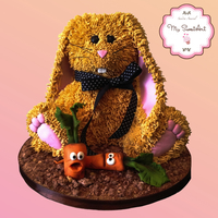 Bunny Cake Bunny cake covered in buttercream. The carrots are made of fondant and the base covered with edible chocolate soil.