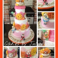 Alice In Wonderland Themed Wedding Cake Three tier Alice in Wonderland themed wedding cake, colours to match bride's dress with hand modelled fondant figures and flowers