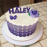 Haley's Birthday Cake. White velvet 7 layer cake with whipped cream and raspberry filling. Iced in frosting pride and decorated with fondant decorations.