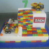Lego Construction Cake Covered in buttercream and fondant. Used the real construction toys. Made all of the lego blocks out of fondant.