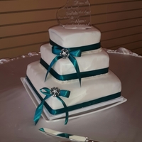 Stacked Wedding Cake The bride wanted teal colored cake on the inside with almond buttercream and white chocolate ganache. It is covered in vanilla fondant with...