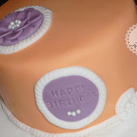 Peach, Purple And Pearl Peach coloured cake with white, purple and pearl details. The rope and the bow were made from wilton moulds