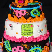 Dia De Los Muertos 3 tier cake covered in fondant with fondant and royal icing accents for a Dia de Los Muertos party. Skull is pre-made resin.
