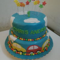 Boy Birthday Cake 2 tier fondant cake with 2 D cars and cloud around the cake and stars at the top