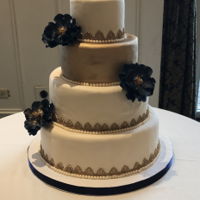 Navy And Gold Wedding Cake Navy and gold themed wedding cake. Satin Ice ivory fondant. Chocolate cake filled with chocolate ganache and raspberries. Used FMM textured...
