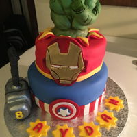 Avengers Birthday cake with Hulk fist Cupcakes with Avengers emblems.