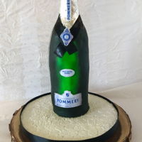 Wine Bottle Cake chocolate cake filled with chocolate buttercream and crumb coat with ganache. The cake is covered with fondant and airbrush to achieve it...