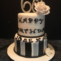 60Th Birthday Theme Cake 2 Tier Coconut Flavored cake with pineapple filling covered in white fondant, flower and number were made out of gumpaste.