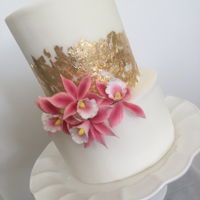 Gold Leaf Straight Edges With Orchids A two tier, straight edge cake with gold leaf and pink orchids.