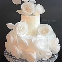 Wafer Paper Cloud This small two-tier wedding cake is adorned with bunches and bunches of modern, bright white wafer paper roses. The top tier is wrapped in...