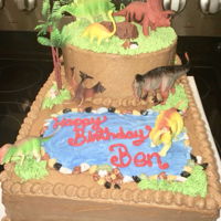 Dinosaur Two Tier Cake This cake was made with all buttercream and it&rsquo;s brown icing not chocolate. Cake toppers were purchased to add to decoration....