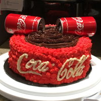 Coca Cola Cake Chocolate layer cake with Chocolate buttercream filling and decorated with Chocolate and Red vanilla Buttercream. The "Coca-Cola"...